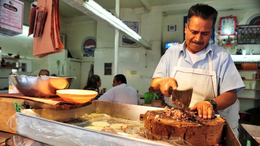 MEXICO CITY - FEB 23 2010:Mexican butcher cuts meat.