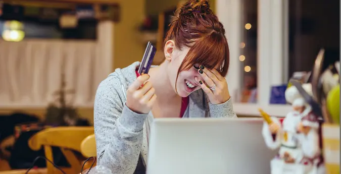woman frustrated at credit card and computer