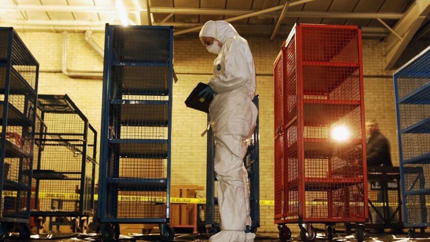 UNSPECIFIED - FEBRUARY 25: A police forensic officer inspects money cages February 25 2006 that were used to store banknotes that were stolen from the Securitas Depot in Tonbridge Kent last week.