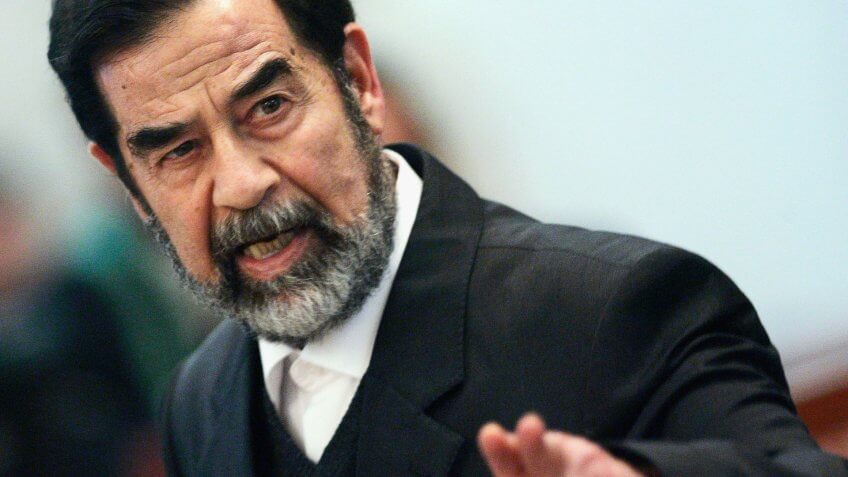 BAGHDAD, IRAQ - FEBRUARY 14: Former Iraqi President Saddam Hussein addresses the court of the Iraqi High Tribunal inside the heavily fortified Green Zone on February 14, 2006 in Baghdad, Iraq.