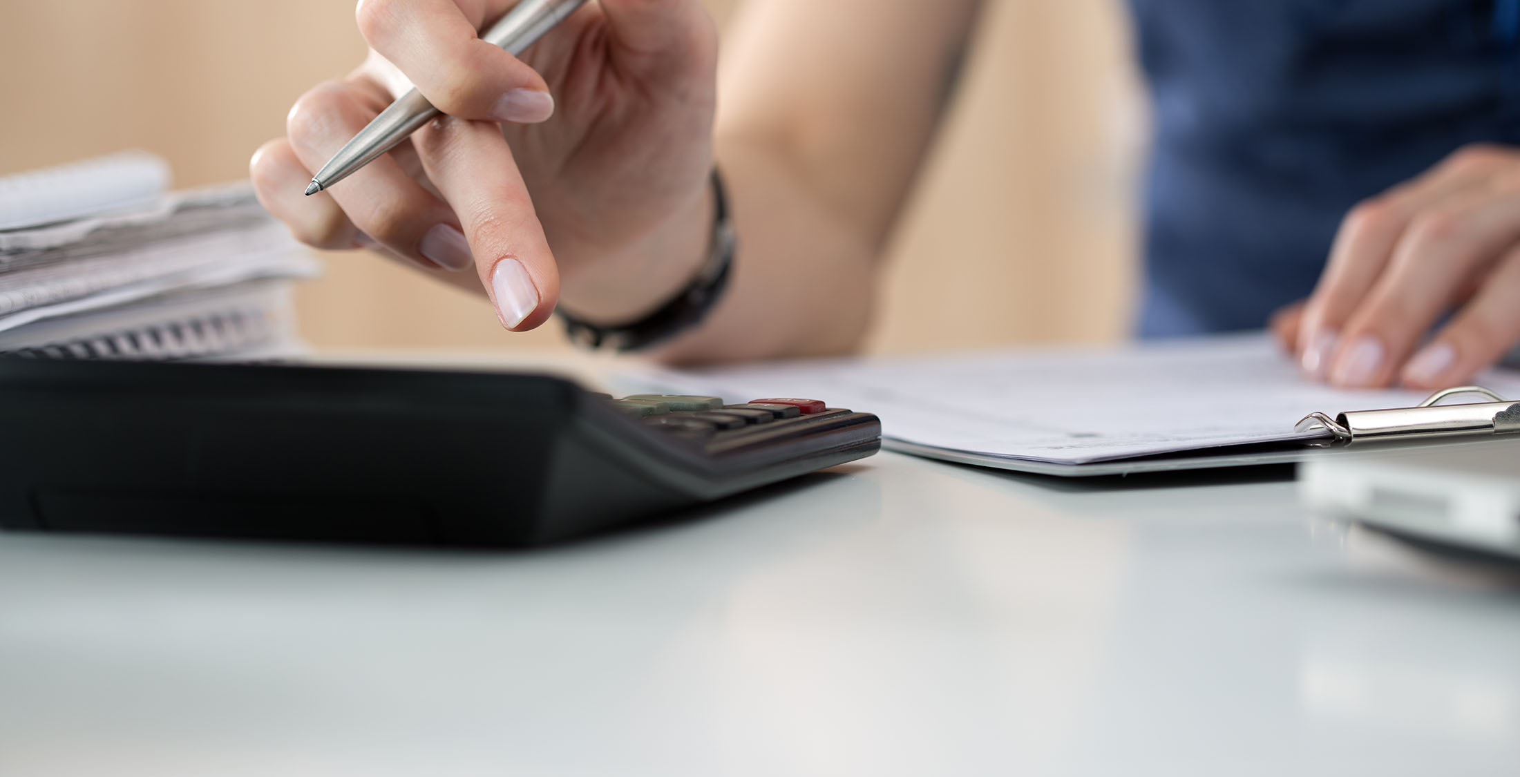 Budget. person typing into calculator