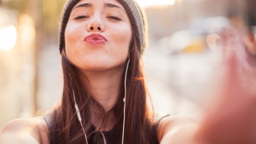 woman with earphones taking a selfie