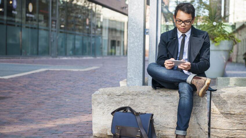 man texting on smartphone outside