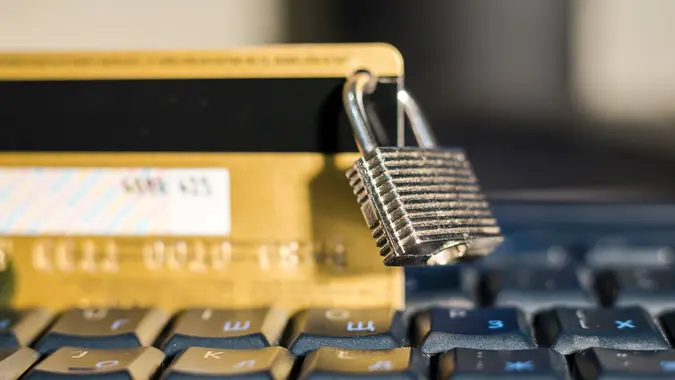 Credit card with hanging padlock on keyboard