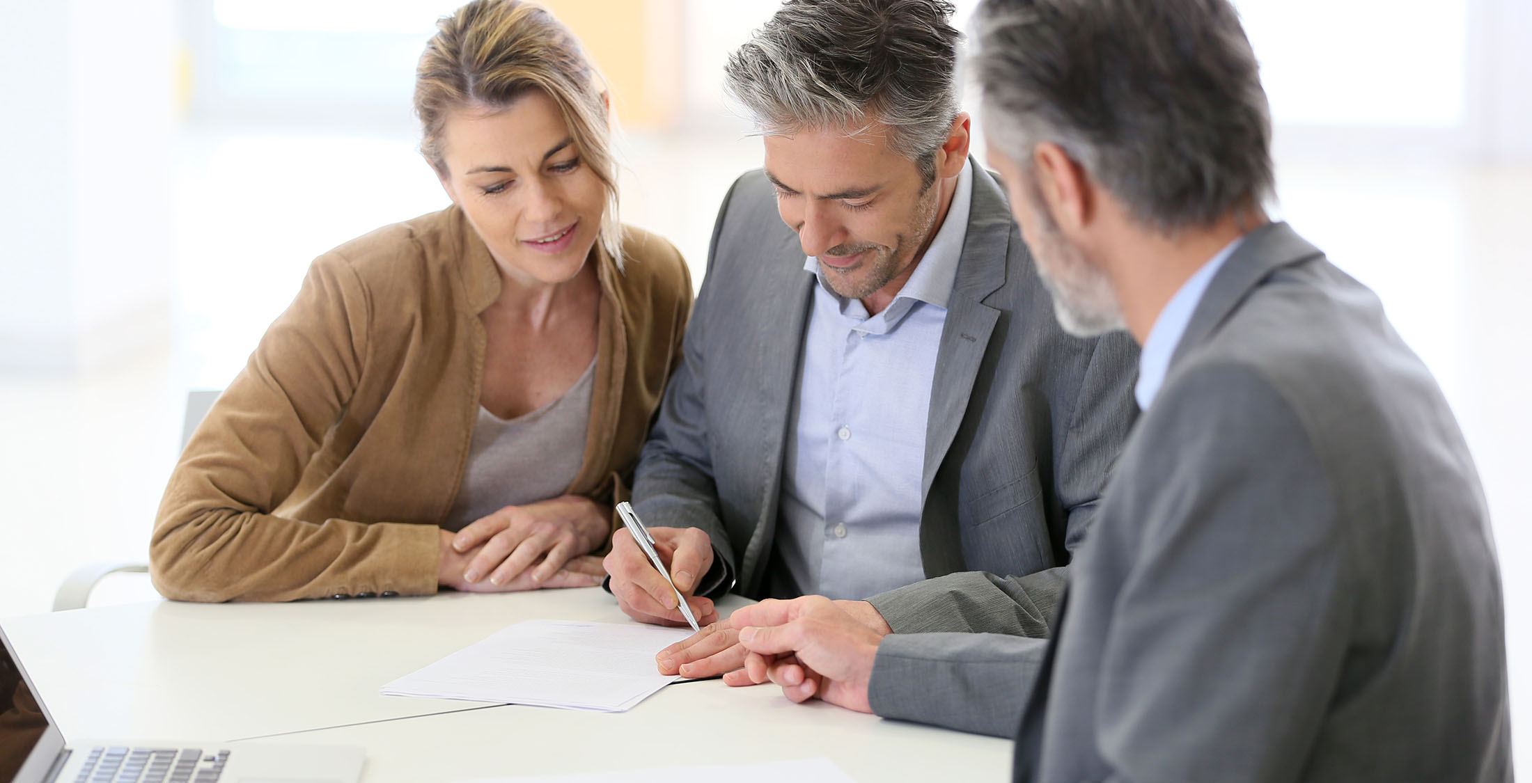 Start your loan search with your credit union or bank. man taking notes with man and woman