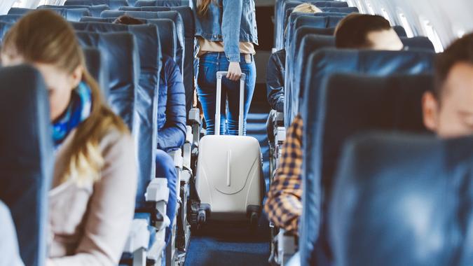 Interior of airplane with people sitting on seats.