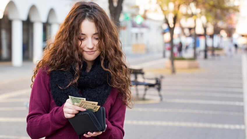 young woman with cash in her wallet