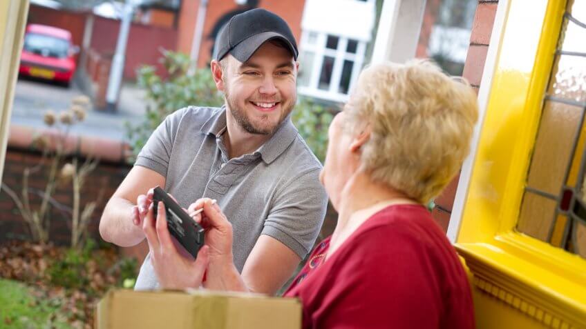 Senior woman signing for her package from courier.