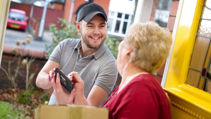 Senior woman signing for her package from courier.