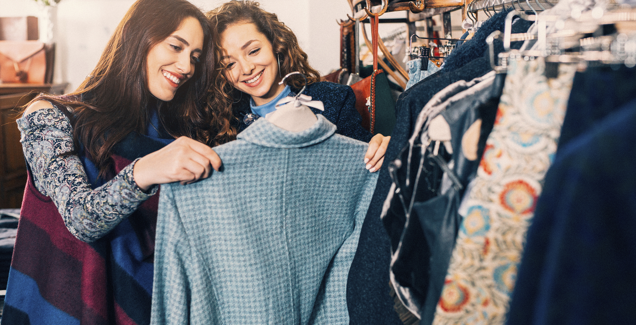 You're busy keeping up with the Joneses. Two friends shopping for clothes in a store