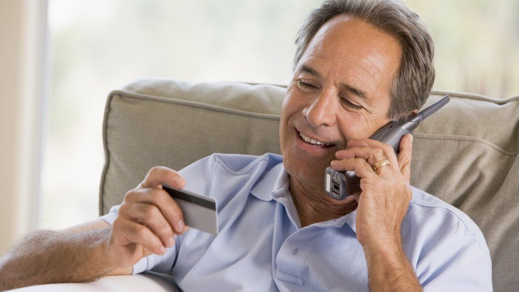 Ask For a Credit Card Limit Increase man on the phone reading credit card information