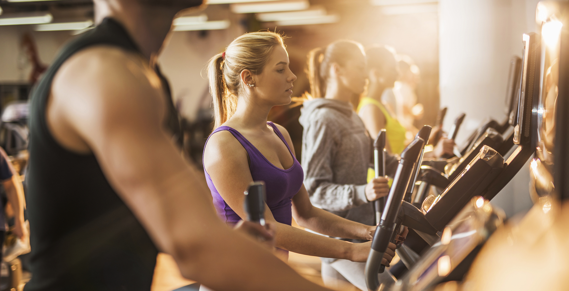 You're still paying for your unused memberships. Group of people exercising on exercise machine in a gym.