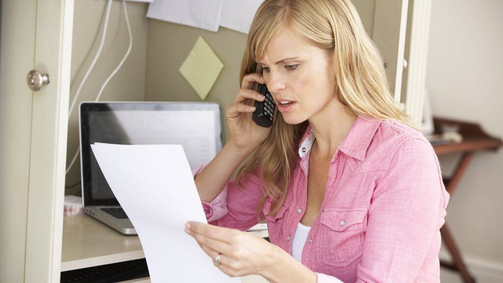 Dispute Errors on Your Credit Report woman on the phone reading business paper