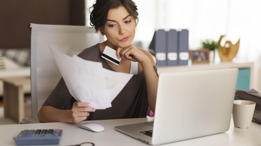 woman working at her desk looking over some papers