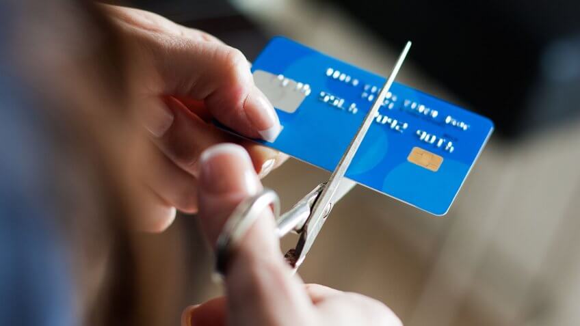 person cutting up their credit card