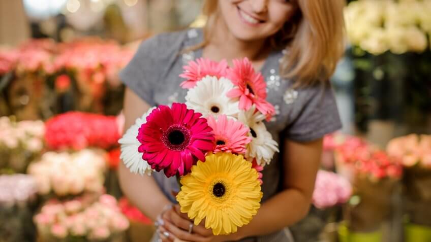 woman holding a bouquet of daisies