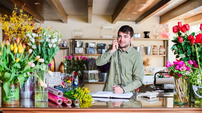 male florist speaking with client on the phone