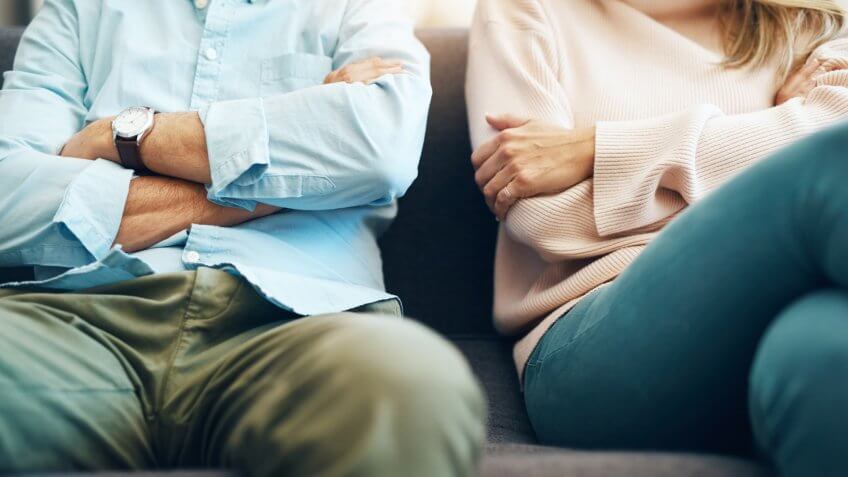 Cropped shot of an unrecognizable mature couple sitting on the sofa with their arms folded after an argument.