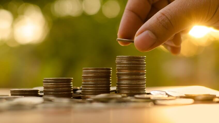 person making a stack of coins
