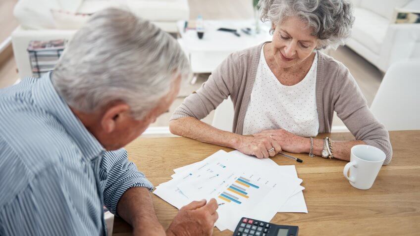 older senior couple reviewing charts and graphs
