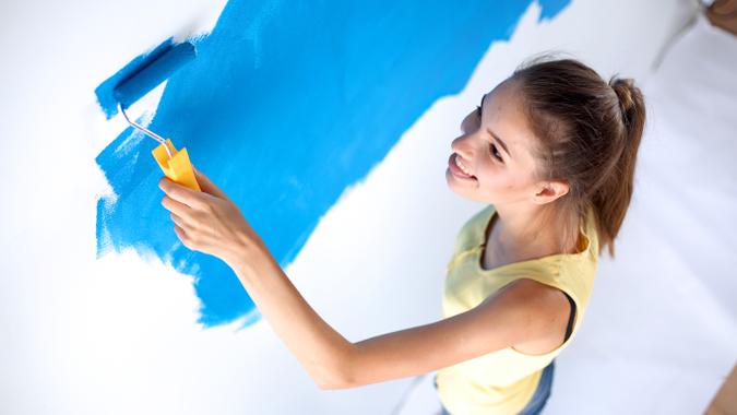 woman painting the walls blue