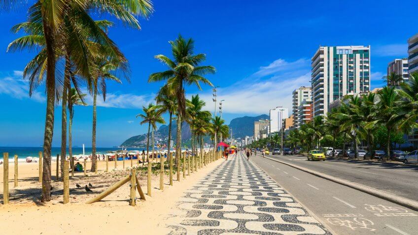 How Much to Tip When Traveling to These 25 Countries, Ipanema beach with mosaic of sidewalk in Rio de Janeiro. Brazil