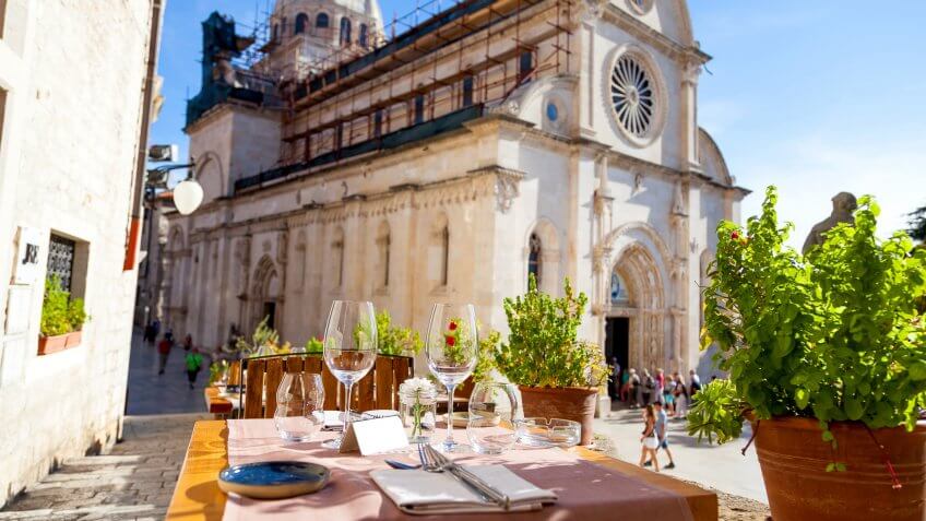 Croatia, Elegant restaurant table waiting for customers, How Much to Tip When Traveling to These 25 Countries, outdoor terrace in the old town of Sibenik