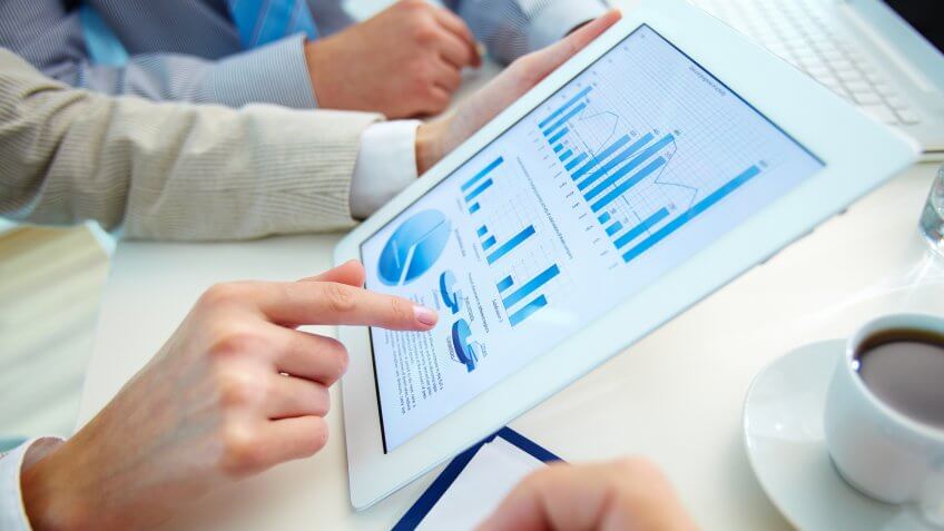 Close up of hands reviewing data on tablet