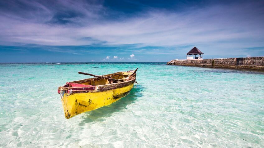 Fishing canoe docked at a beach in clear shallow water, north coast Jamaica.