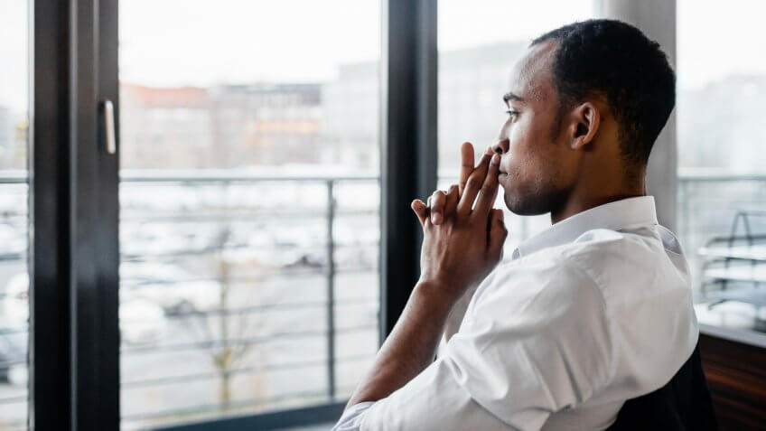 Young businessman in chair looking out window