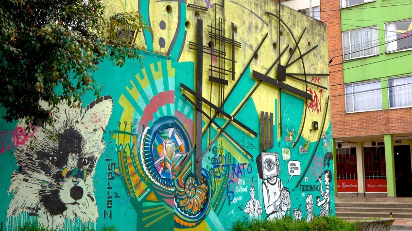 Bogota, Colombia - July 20, 2013: A street side wall completely painted up by Colombian Street Artist who signs off as 'Toxicomano', in La Candelaria, in the Andean capital city of Bogota in Colombia; the painting combines stencil work with painting and has some social messages: a person's eyes closed by another person whose head is a TV.