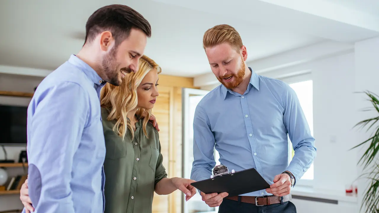 Young couple consulting with financial adviser at home.