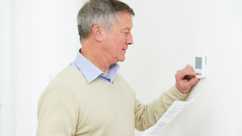 man adjusting the thermostat