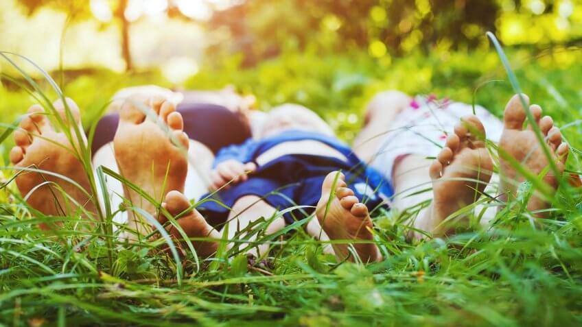 family laying in the grass at the part