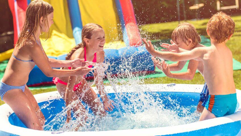 kids playing in an inflatable swimming pool