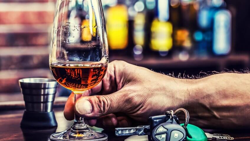 glass of alcohol next to a set of car keys