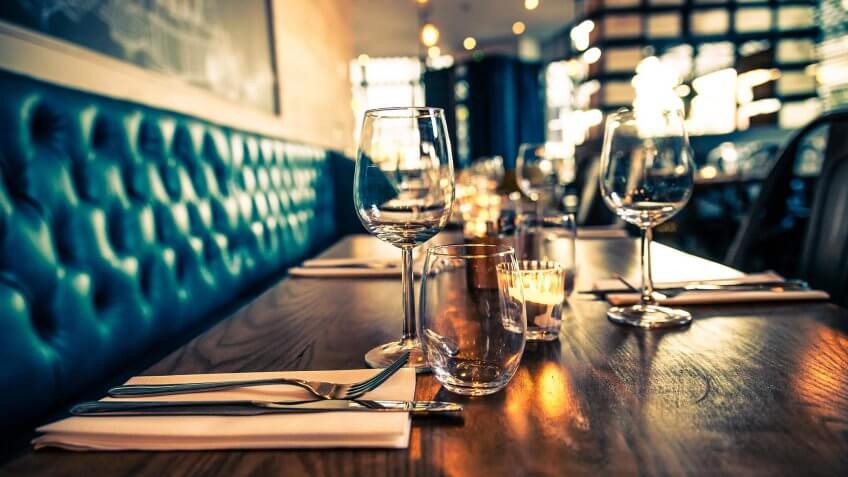 empty restaurant with wine glasses on the tables