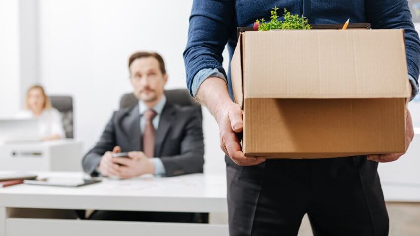 employee leaving job with belongings packed in a box
