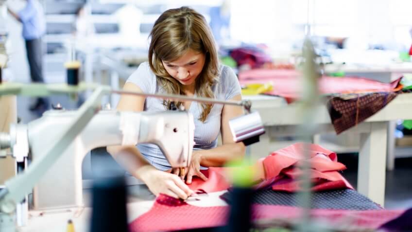 Young woman working in a clothes factory.