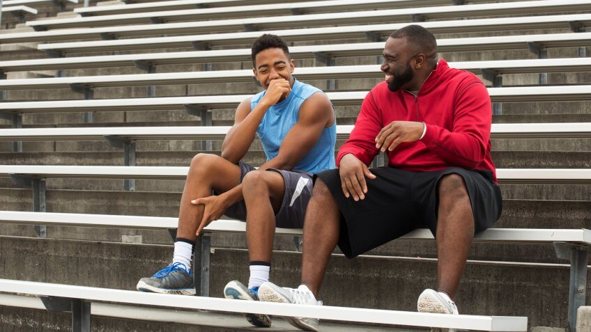 El entrenador pasa tiempo como mentor de un estudiante atleta.