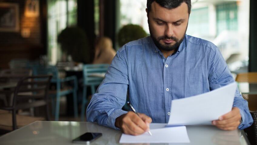 man reading and signing documents