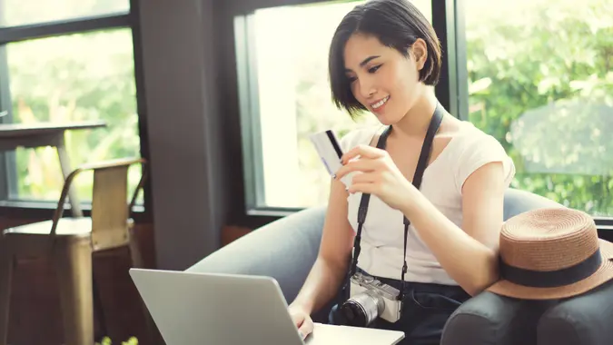 woman looking at her credit card and laptop