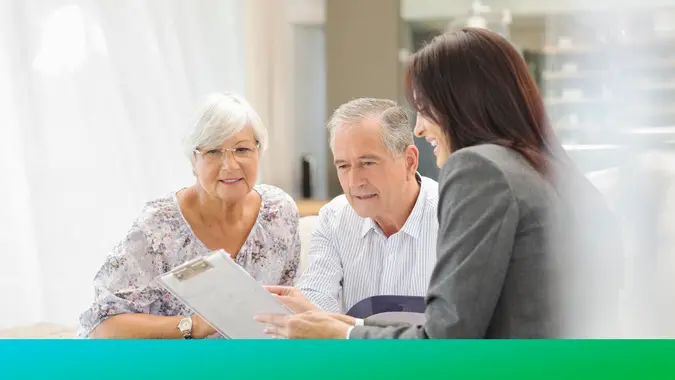 Financial advisor talking to couple on sofa.