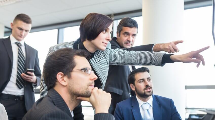Business people pointing at screen.