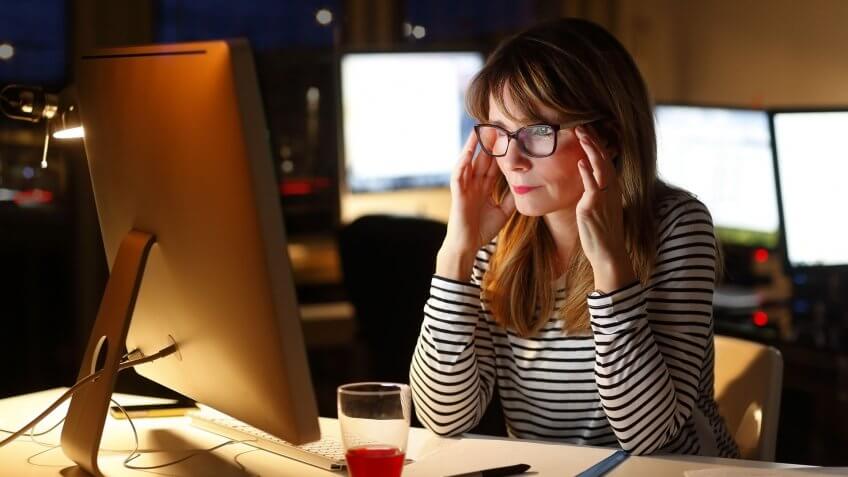 a stressed-focused woman working on an imac