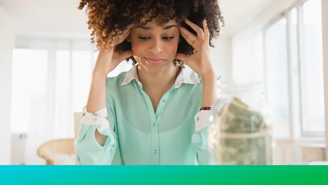 Stressed mixed race woman paying bills.