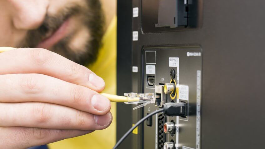 man plugging in cord to computer