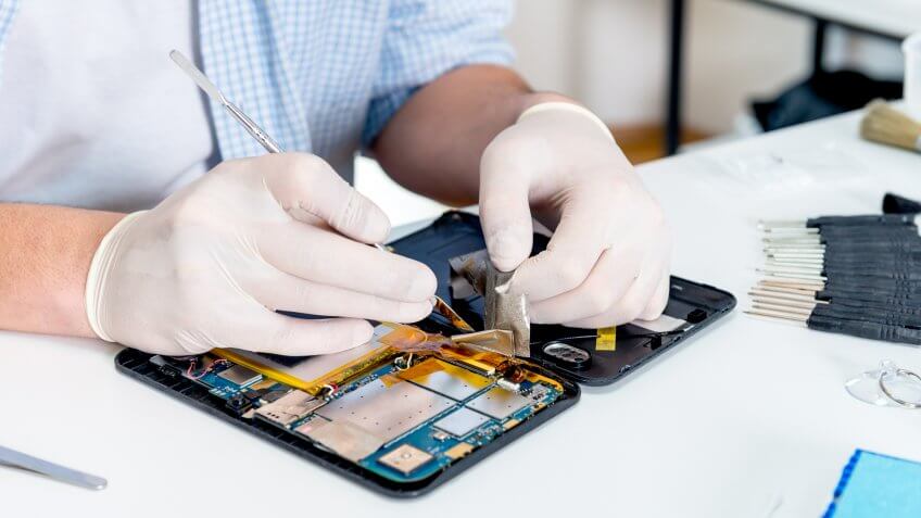 hands fixing phone tech