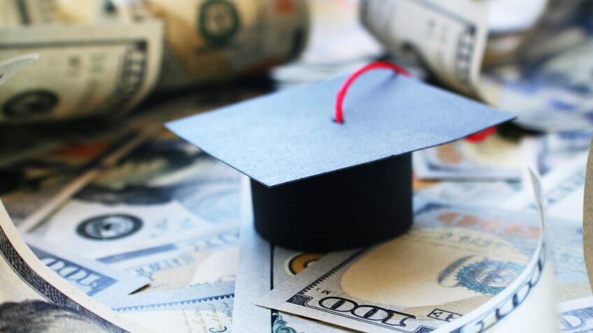 Student loans are a big burden for these seven states. graduation cap on top of cash