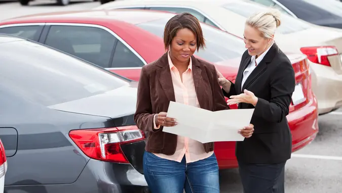 Woman shopping for a new car, with a saleswoman.